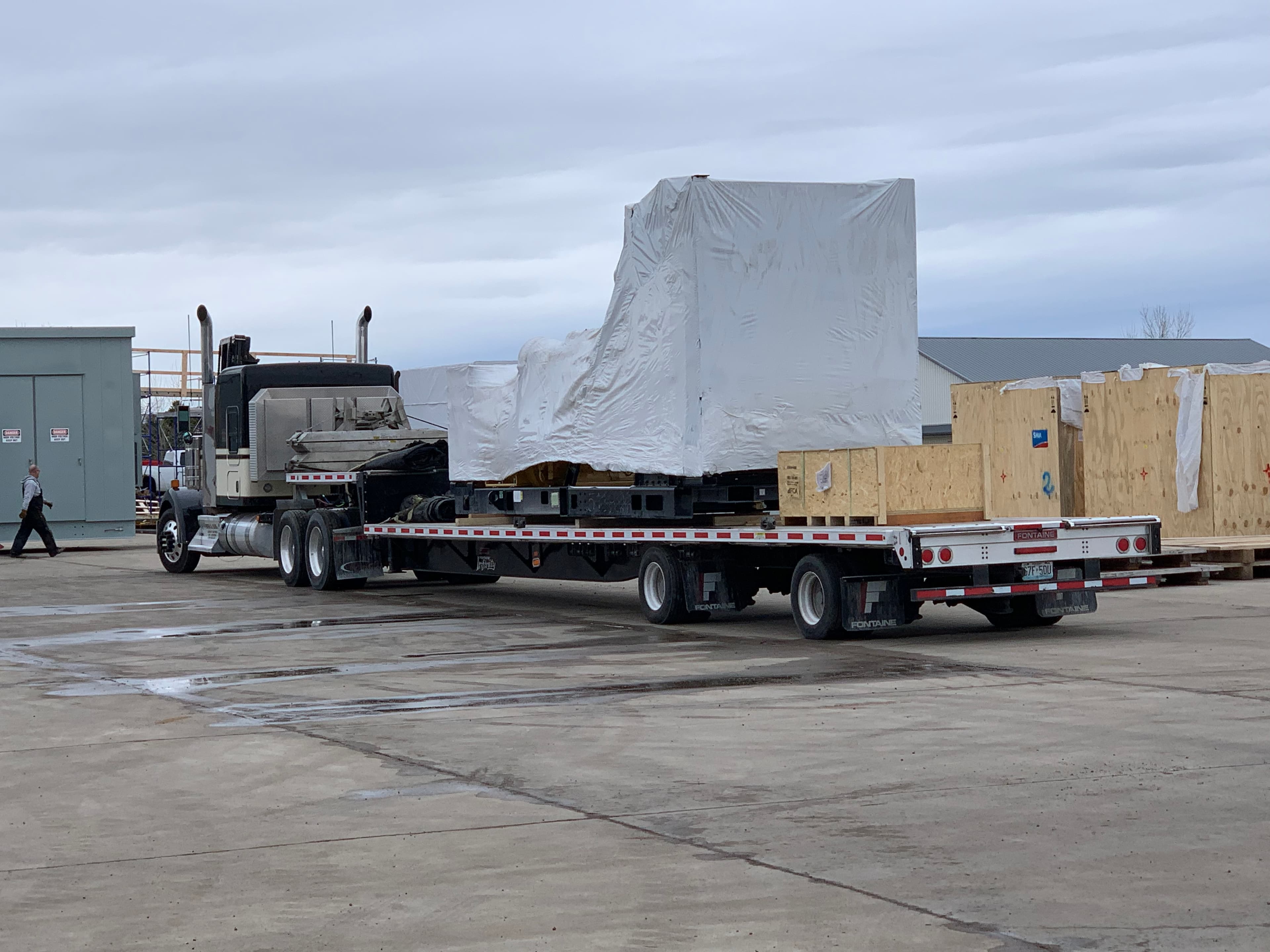 RGN trailer carrying shrink-wrapped industrial machinery